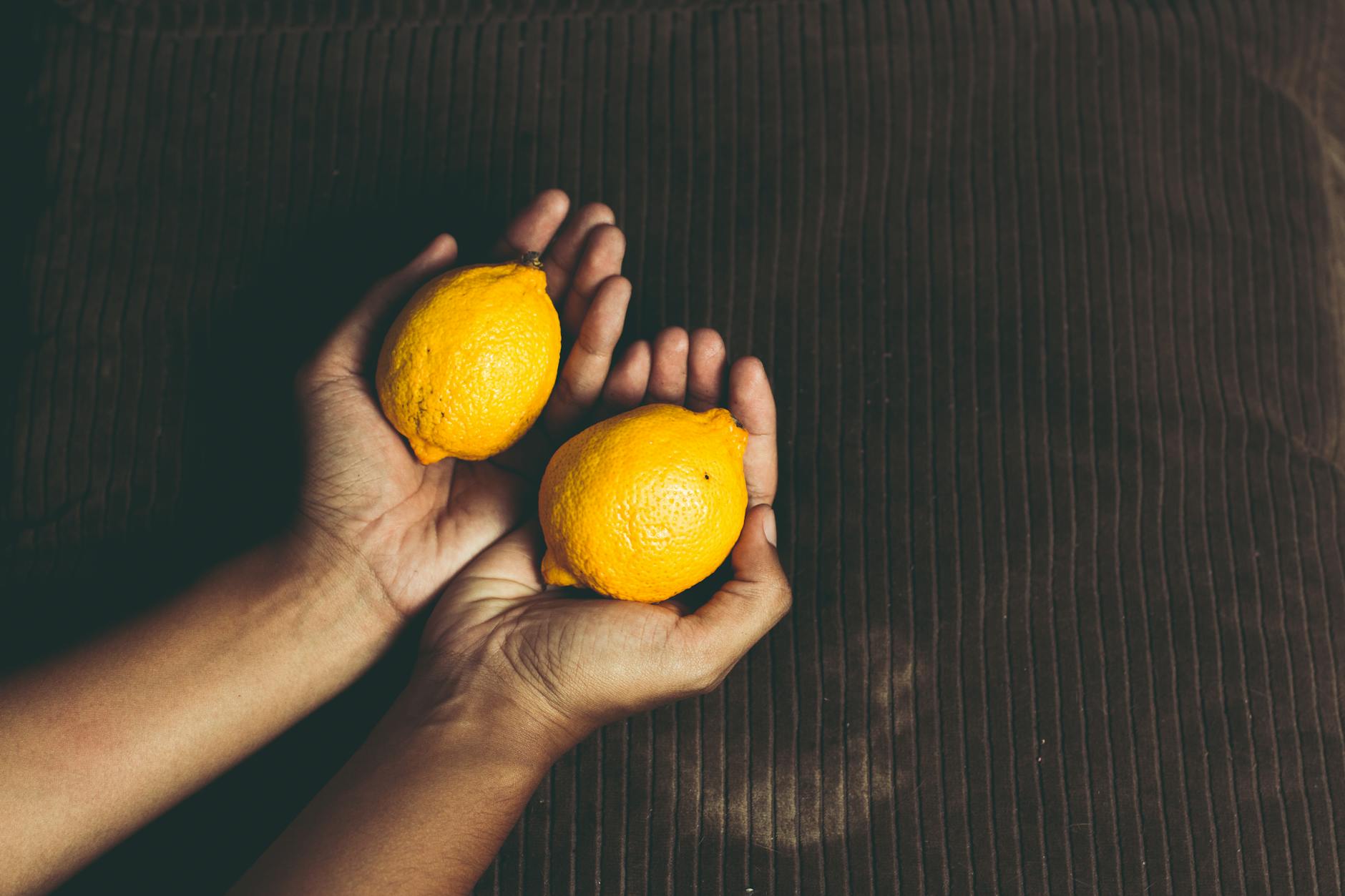 Bright yellow lemons on pastel green background, representing fresh intimate connection
